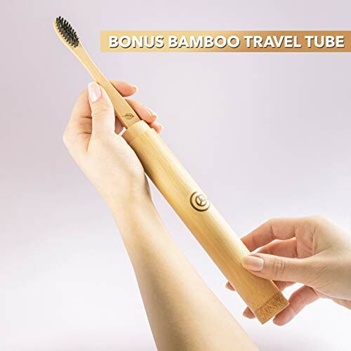 Person holding bamboo toothbrush and travel tube.